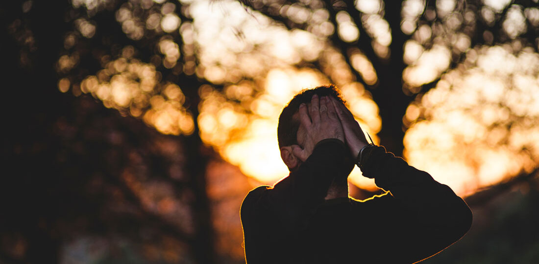 Man holding face with hands