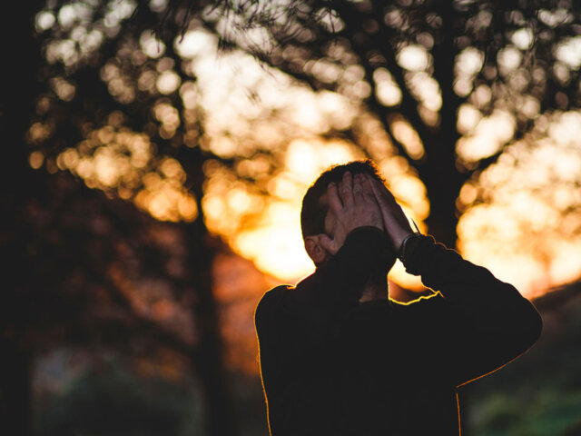 Man holding face with hands