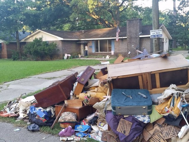 Home with interior debris on front curb