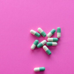 Medication capsules on pink background