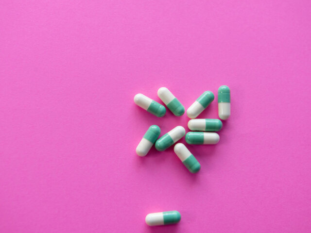 Medication capsules on pink background