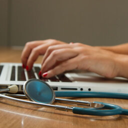 Doctor at computer with stethoscope