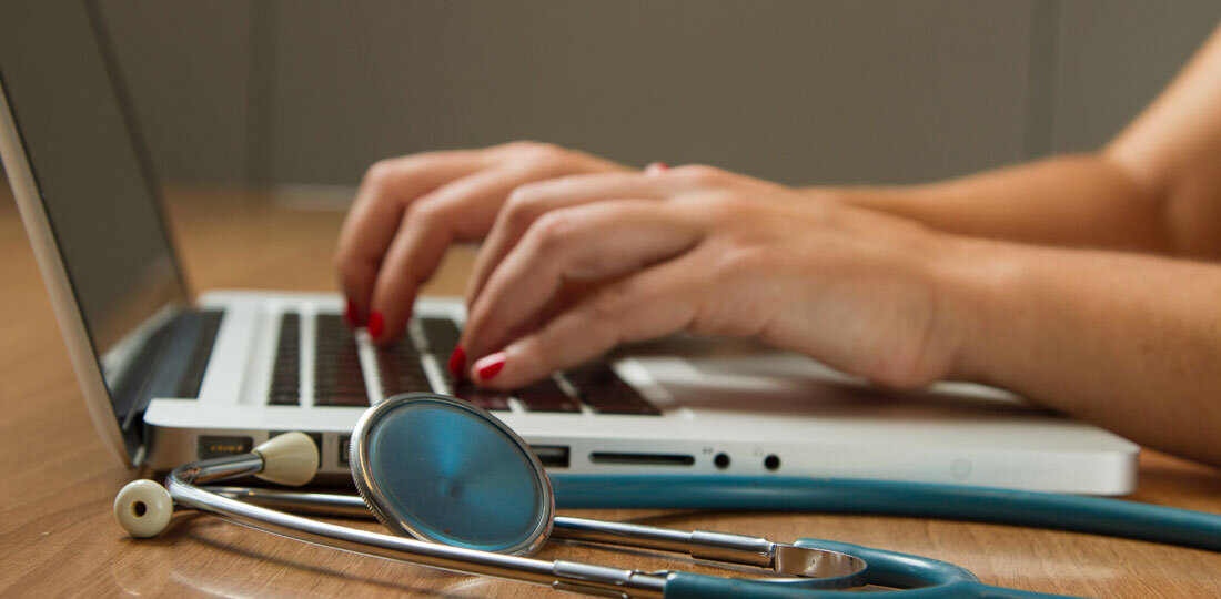 Doctor at computer with stethoscope