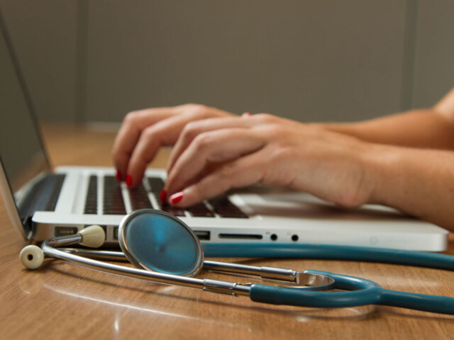 Doctor at computer with stethoscope