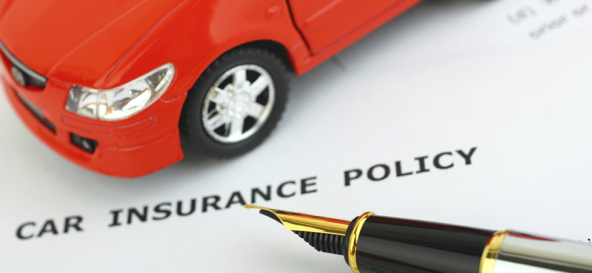 Toy car on top of auto insurance policy