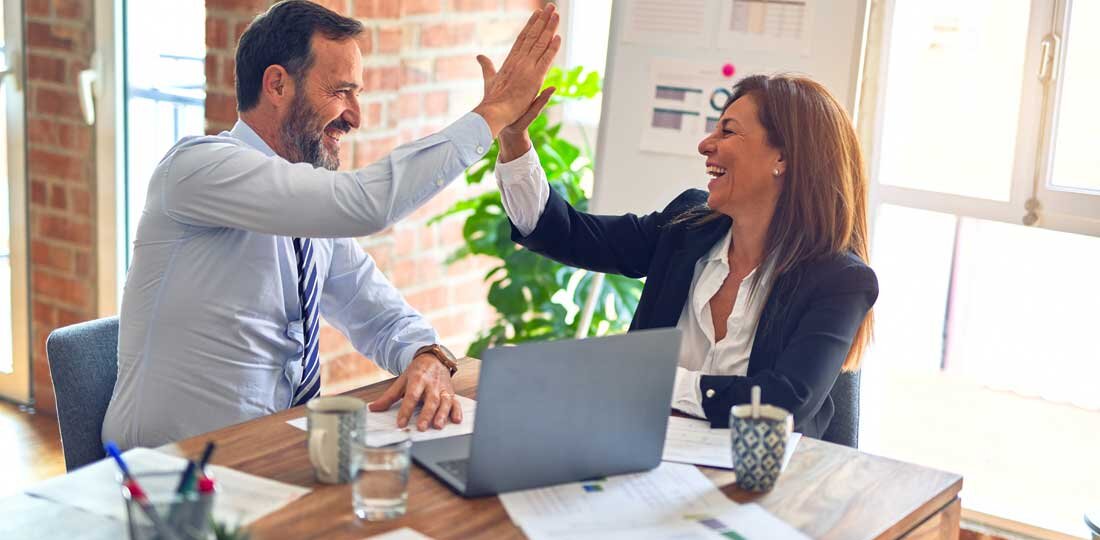 Man and woman giving high five at desk