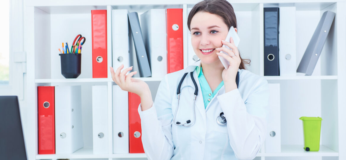 Woman in lab coat on phone