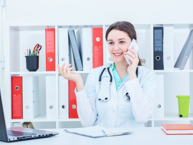 Woman in lab coat on phone