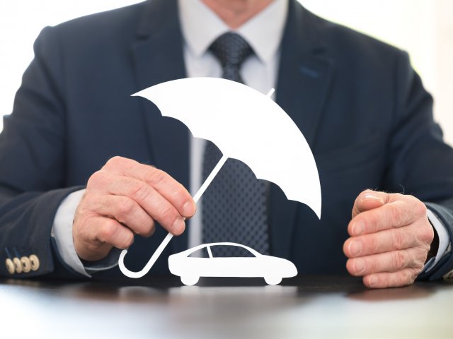 Paper car under umbrella