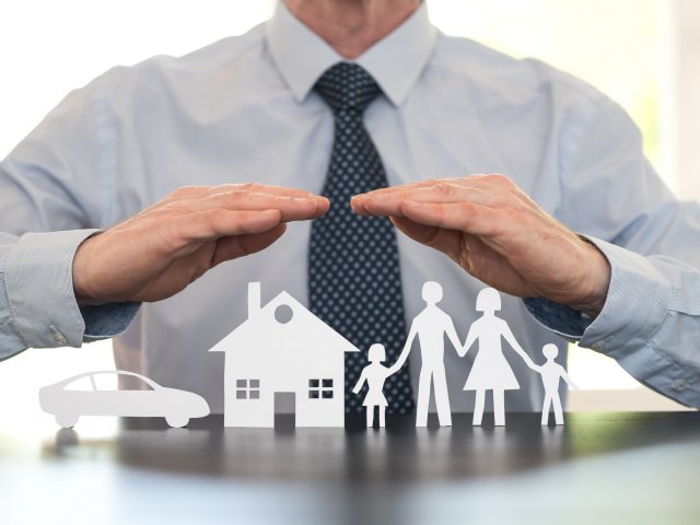 Man with hands over cutout family