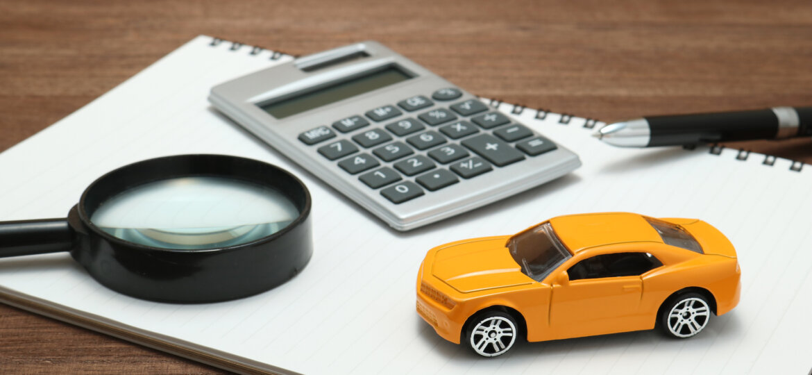 Toy car, magnifying glass, calculator, pen and notebook